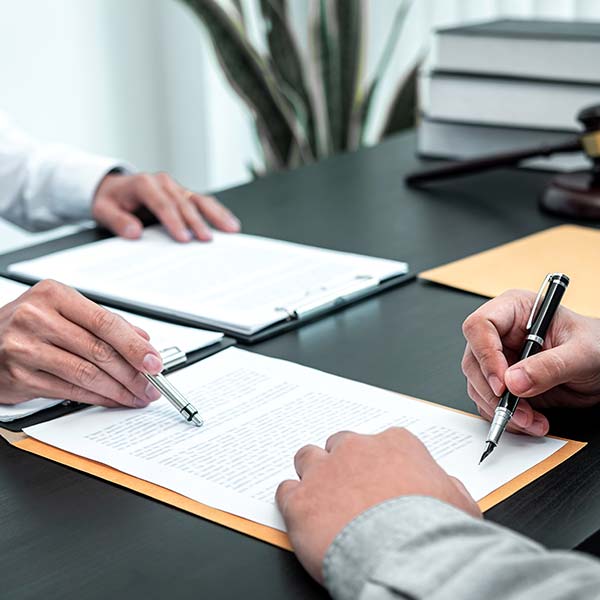 Client signing on a paper at the lawyer's office